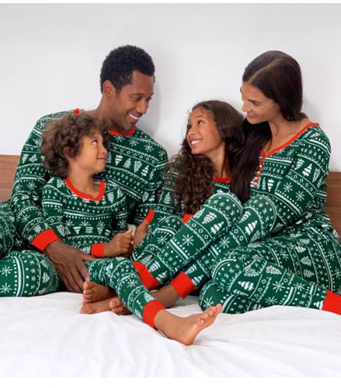 Family of four wearing matching green pajamas with white trees.